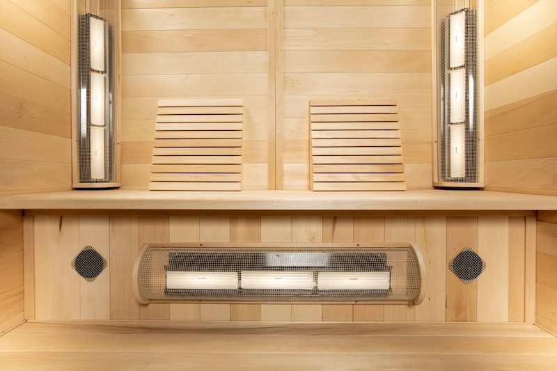 A close-up shot of a SaunaRay infrared sauna bench and heater